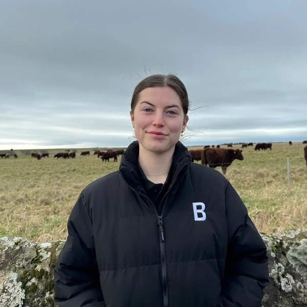Katie MacAuley, Bowhouse team Katie MacAuley of the Bowhouse team, standing in a field with cattle behind