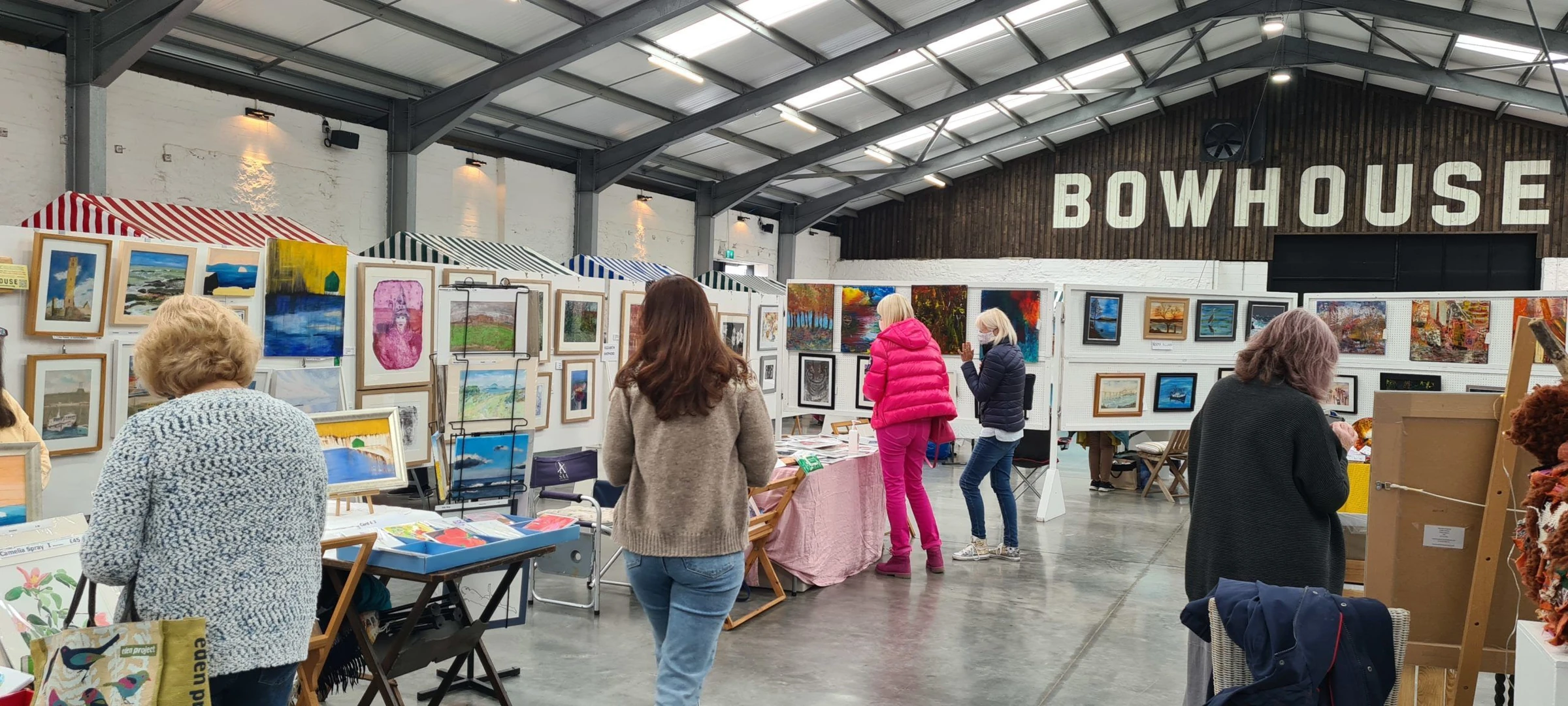 Art fair in the Bowhouse hall Visitors browsing art stalls beneath the Bowhouse sign in the hall